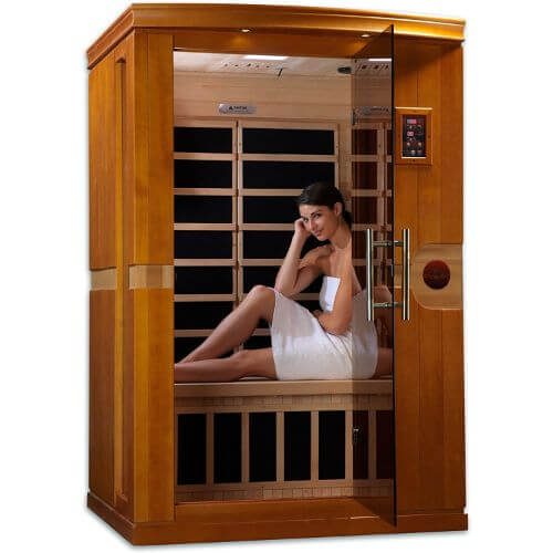 wooden sauna with glass door and a woman sitting inside