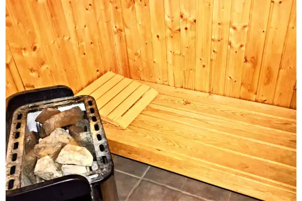 sauna heater filled with rocks kept inside a wooden room