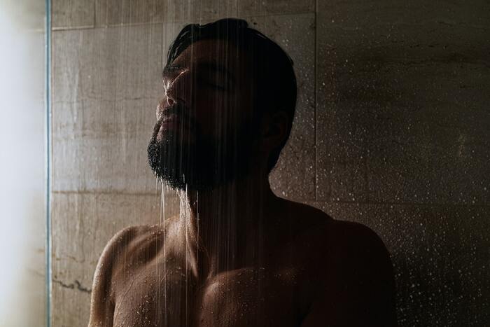 man taking a shower after a sauna session