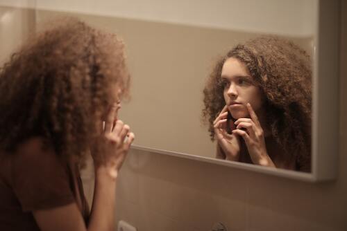 woman examining her skin in the mirror!