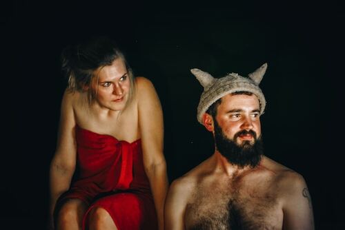 man wearing sauna hat with a woman by his side